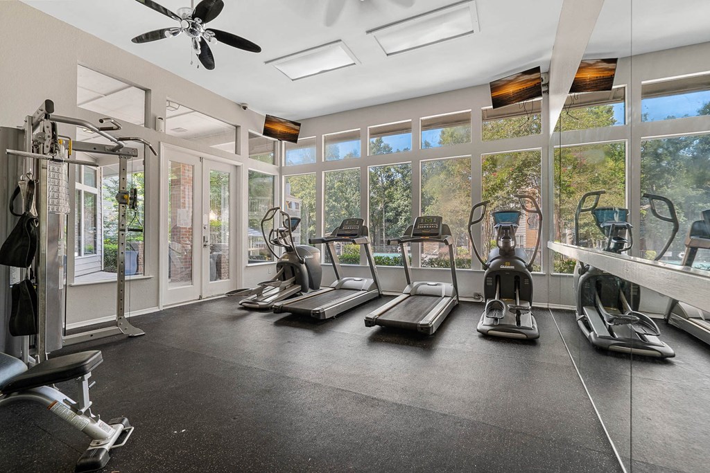 a gym with a lot of machines and windows