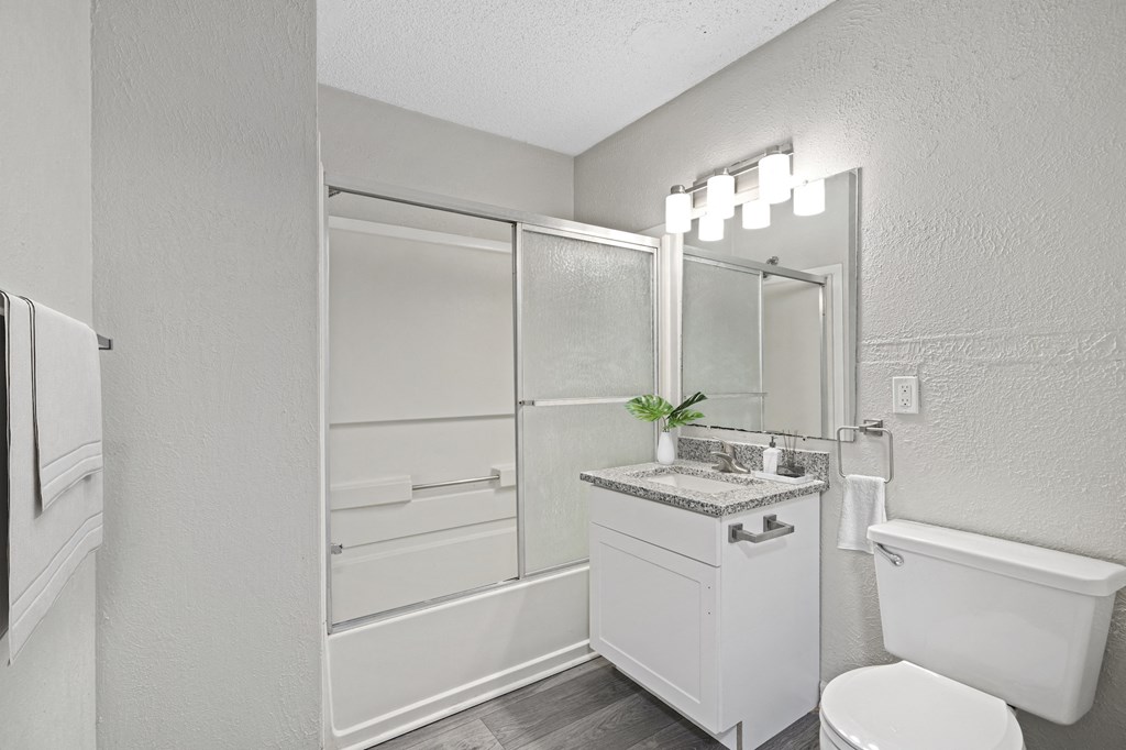 a bathroom with a toilet sink and shower