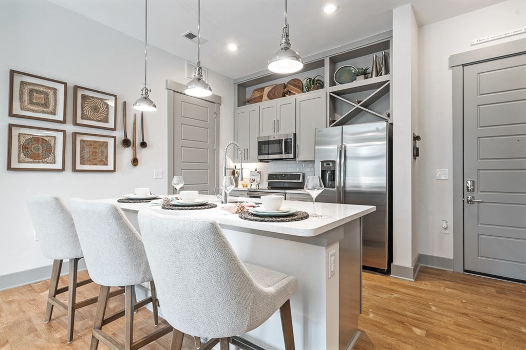 Kitchen island breakfast bar with designer chairs and stainless steel appliances
