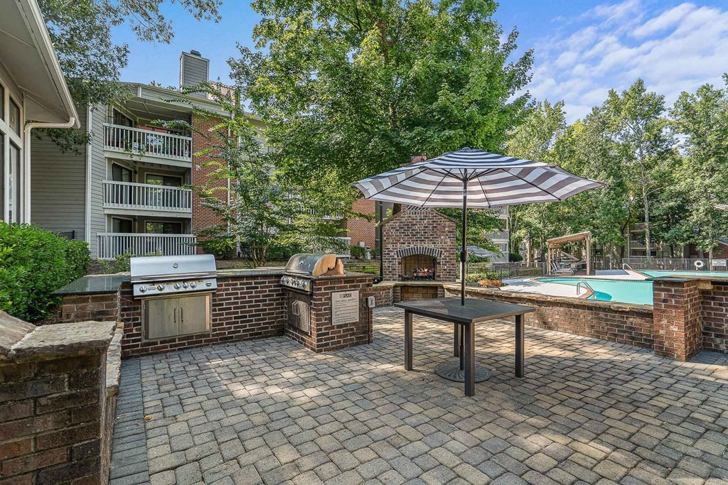a patio with an umbrella and a swimming pool