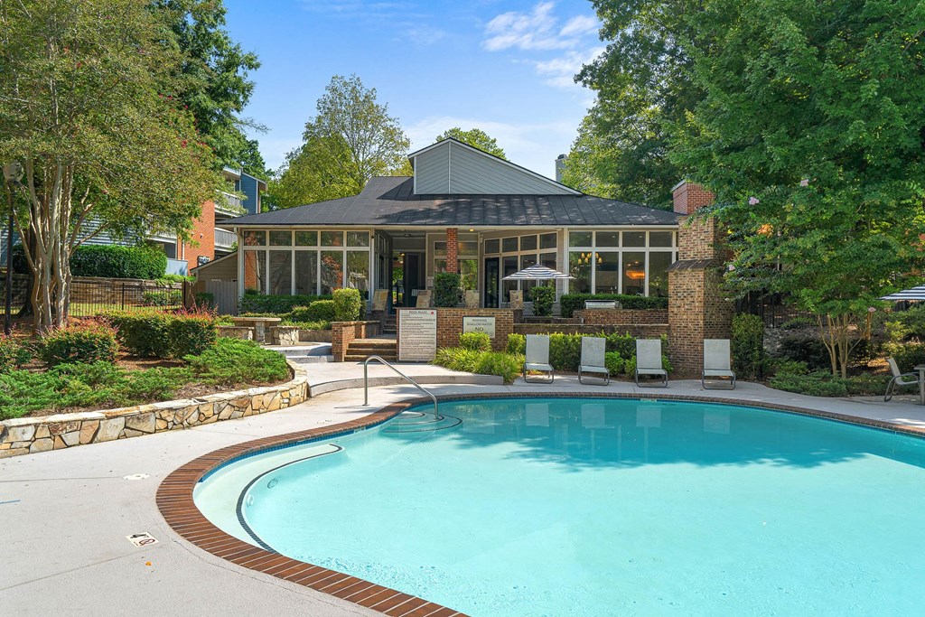 a swimming pool in front of a house with a pool