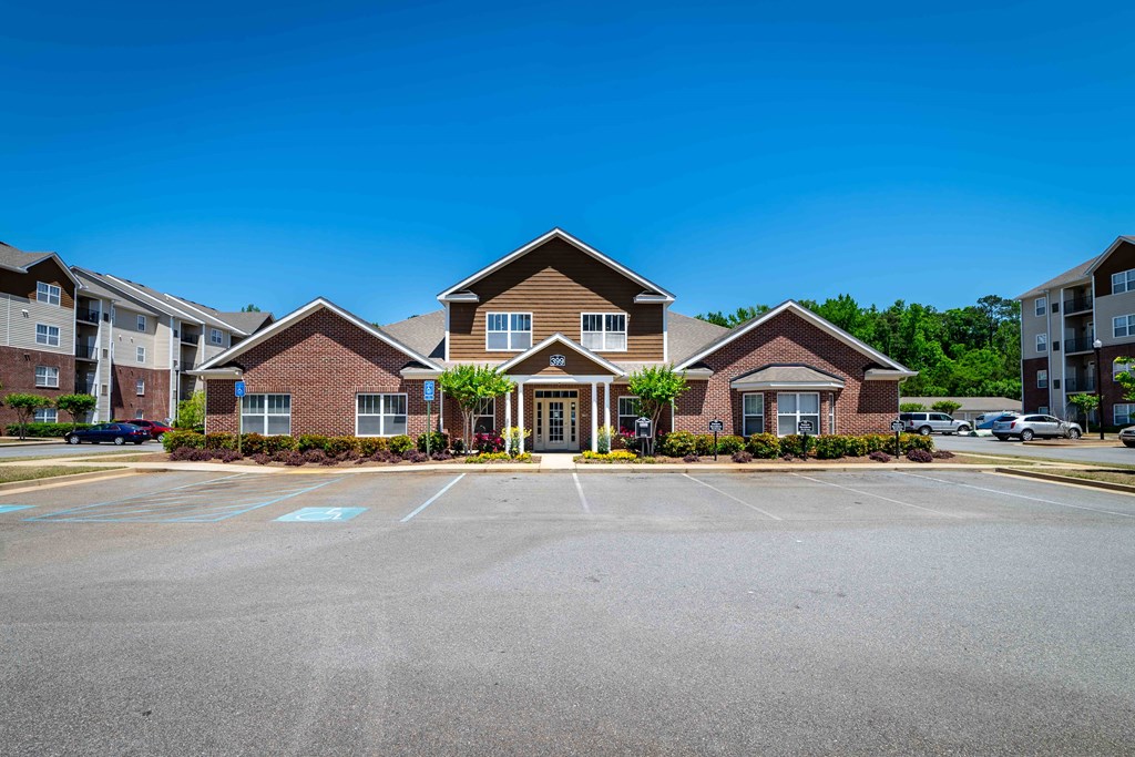 an empty parking lot in front of a brick house
