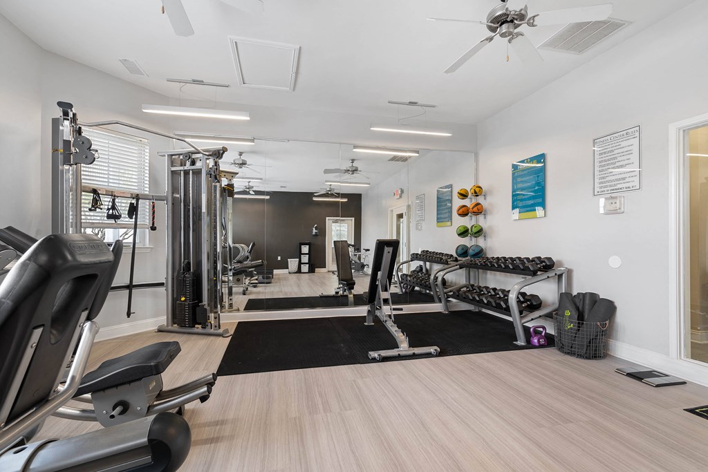 a gym with exercise equipment and a ceiling fan