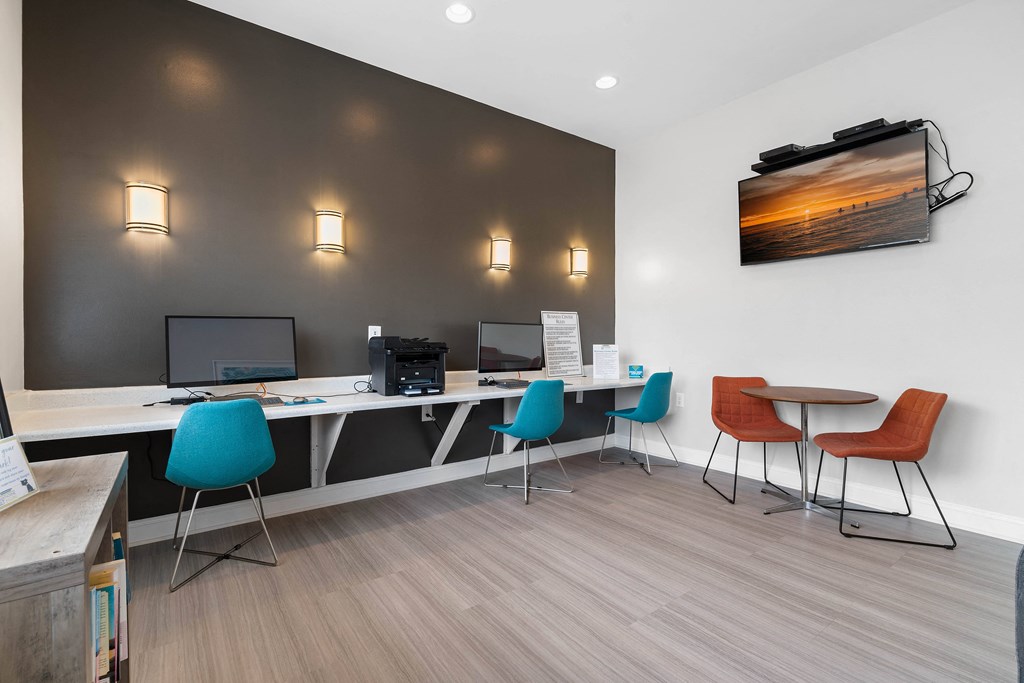 a modern office with desks and chairs and a tv