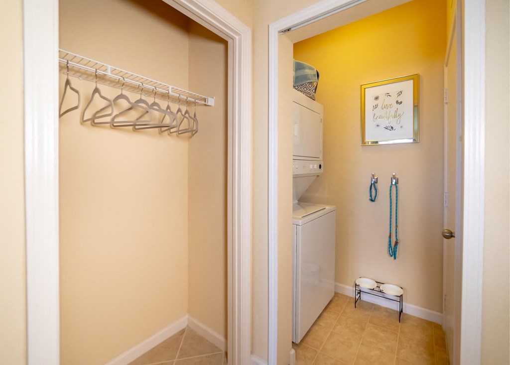 a bathroom with a closet and a washer and dryer in it