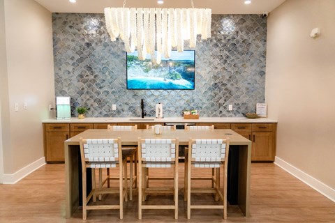 A kitchen with a table and chairs in front of a television.