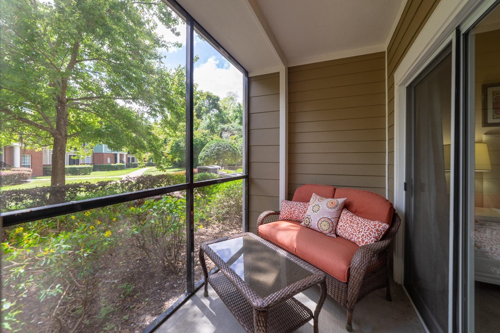 a porch with a couch and a table and a large window