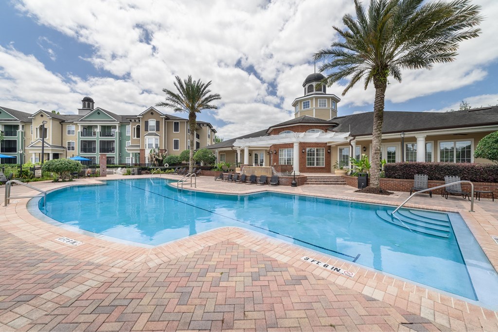 a large swimming pool with a mansion in the background