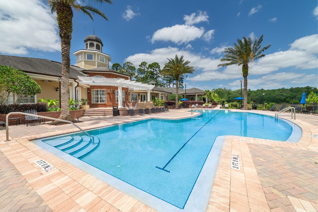 a large swimming pool with a resort style hotel in the background