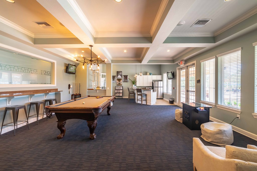 a game room with a pool table and a bar