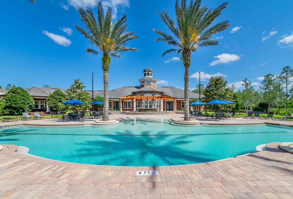 a swimming pool at a resort with palm trees