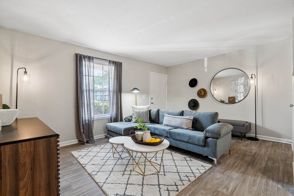 a living room with a blue couch and a round coffee table