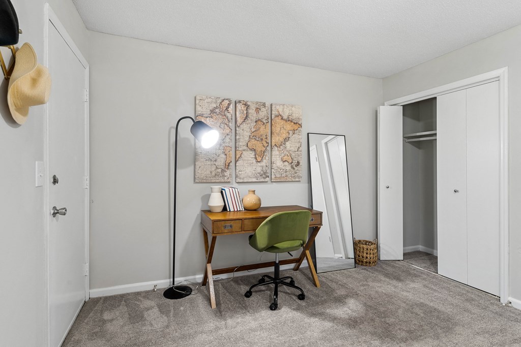 a home office with a desk and a lamp and a map on the wall
