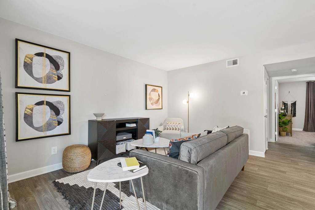 a living room with a gray couch and a white table