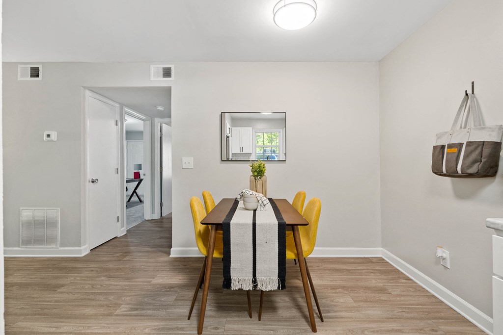 a dining room with a wooden table and yellow chairs