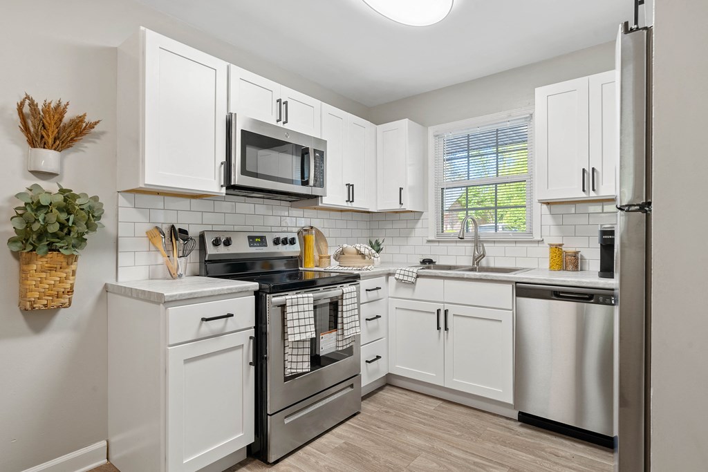 a kitchen with stainless steel appliances and white cabinets