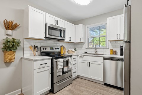 a kitchen with stainless steel appliances and white cabinets