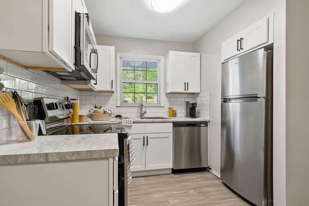 a renovated kitchen with stainless steel appliances and white cabinets