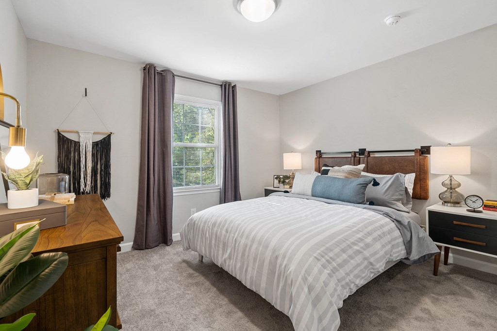 a bedroom with a bed and a dresser and a window