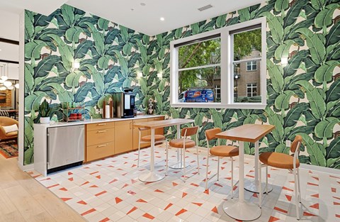 a kitchen with banana leaf wallpaper and a table with chairs