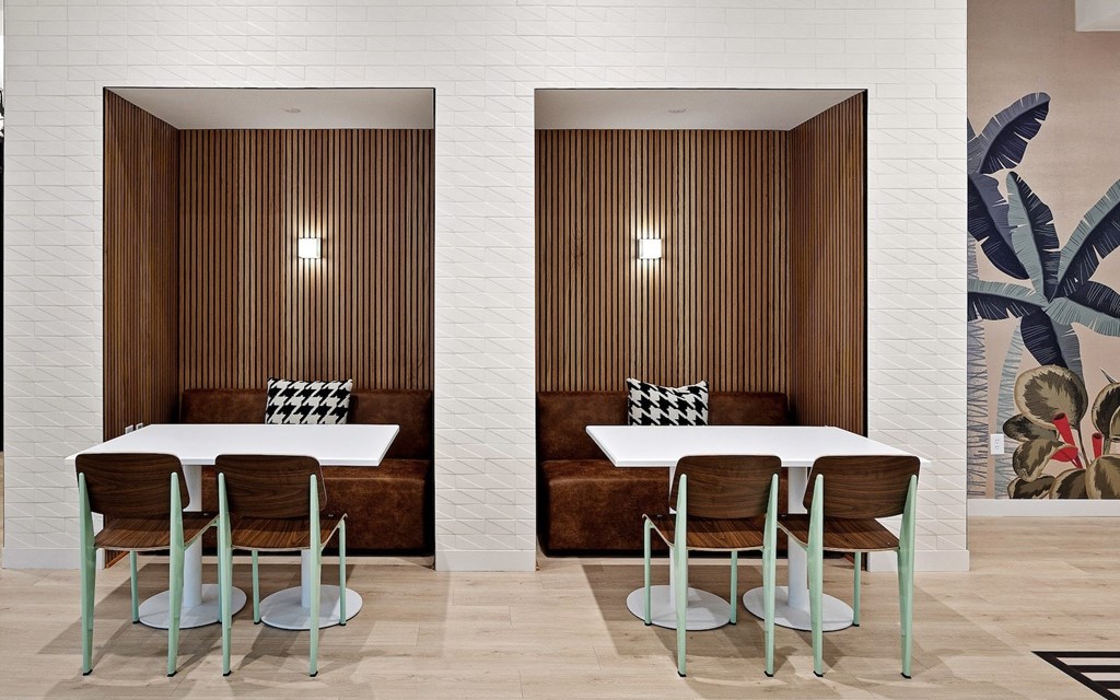 a meeting room with two tables and chairs and a wall mural