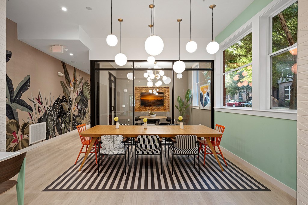 a dining room with a wooden table and chairs and a large window