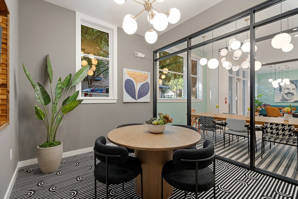 a dining room with a table and chairs and a potted plant