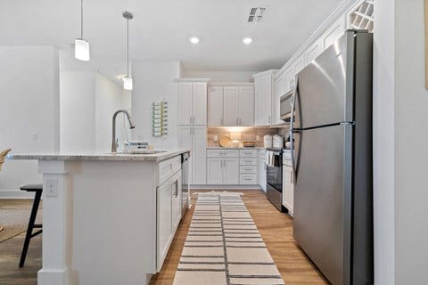 A modern kitchen with a large island and stainless steel appliances.