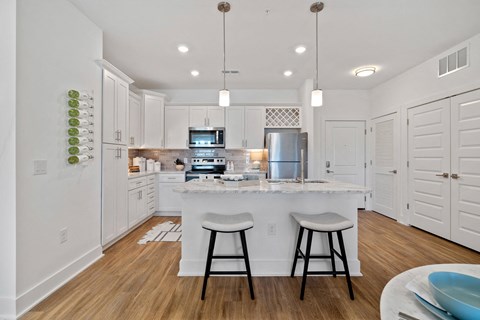 A modern kitchen with white cabinets and a central island.