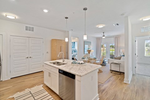 A modern kitchen with a large island and wooden floors.