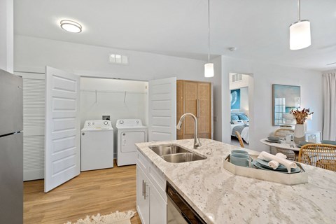 A modern kitchen with a marble countertop and stainless steel appliances.
