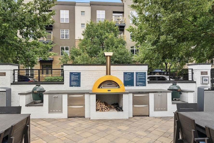 a pizza oven in a courtyard with a table and chairs