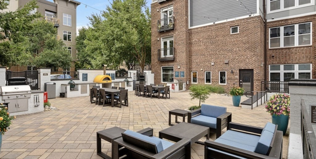 a patio area with tables and chairs and a brick building