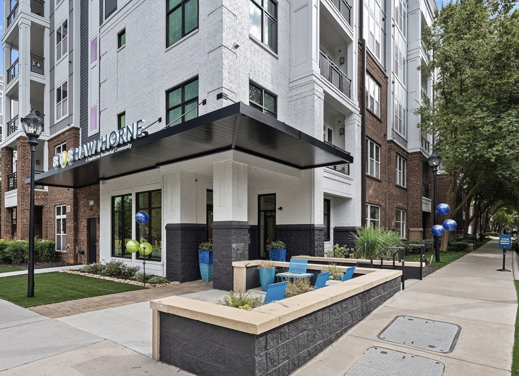 an apartment building with a seating area and a sidewalk