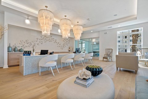 A modern living room with a white couch and a round ottoman.