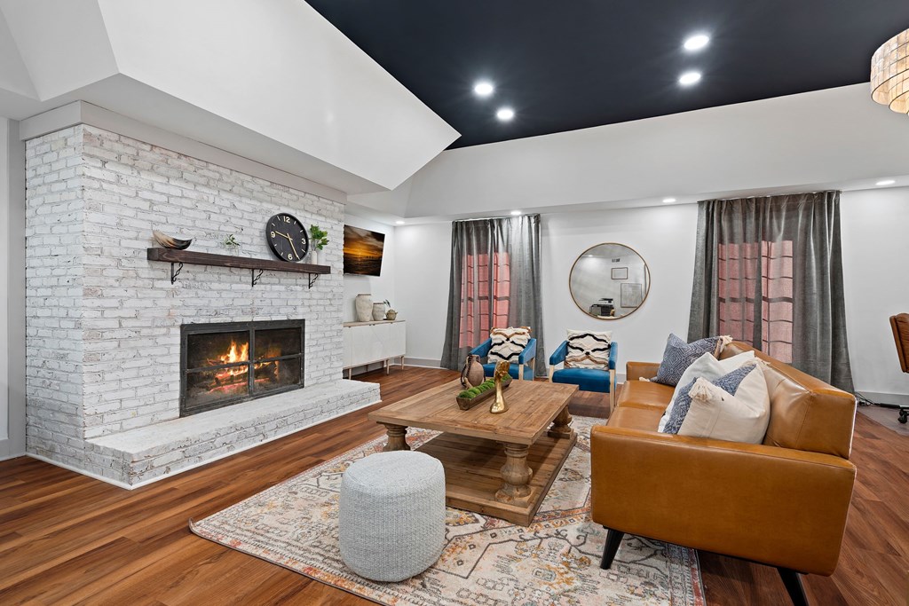 the living room has a brick fireplace and leather furniture