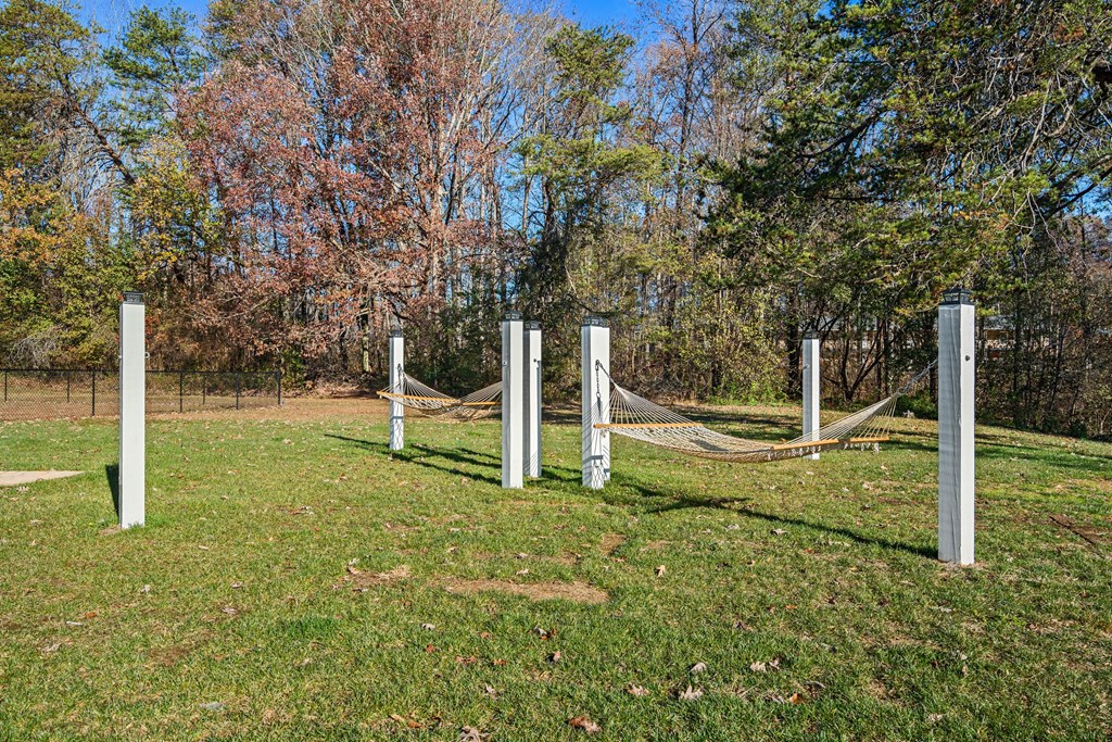 a chain link fence with a hammock in the grass