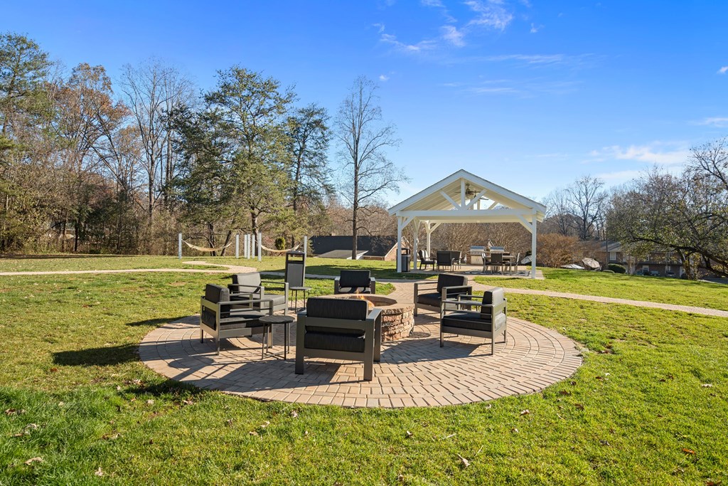 a patio with chairs and a gazebo in a park