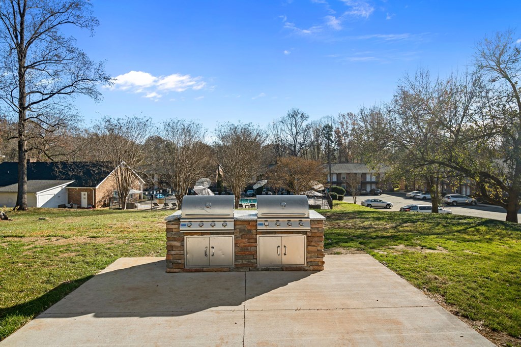 a stainless steel grill on a sidewalk in a park