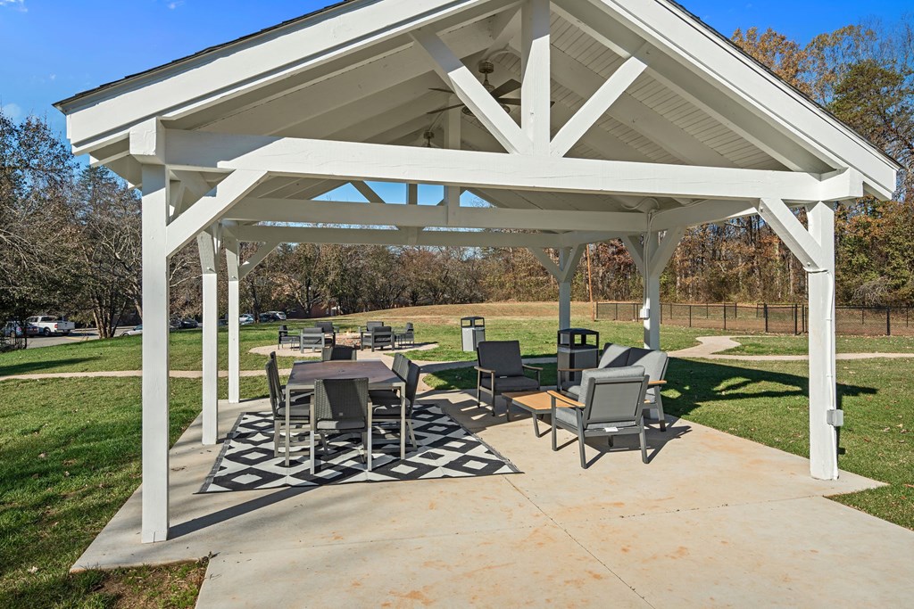 a patio with tables and chairs under a pavilion