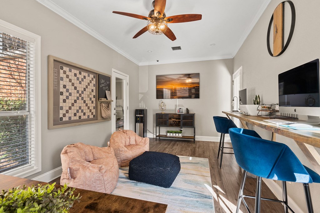 a living room with a ceiling fan and a tv