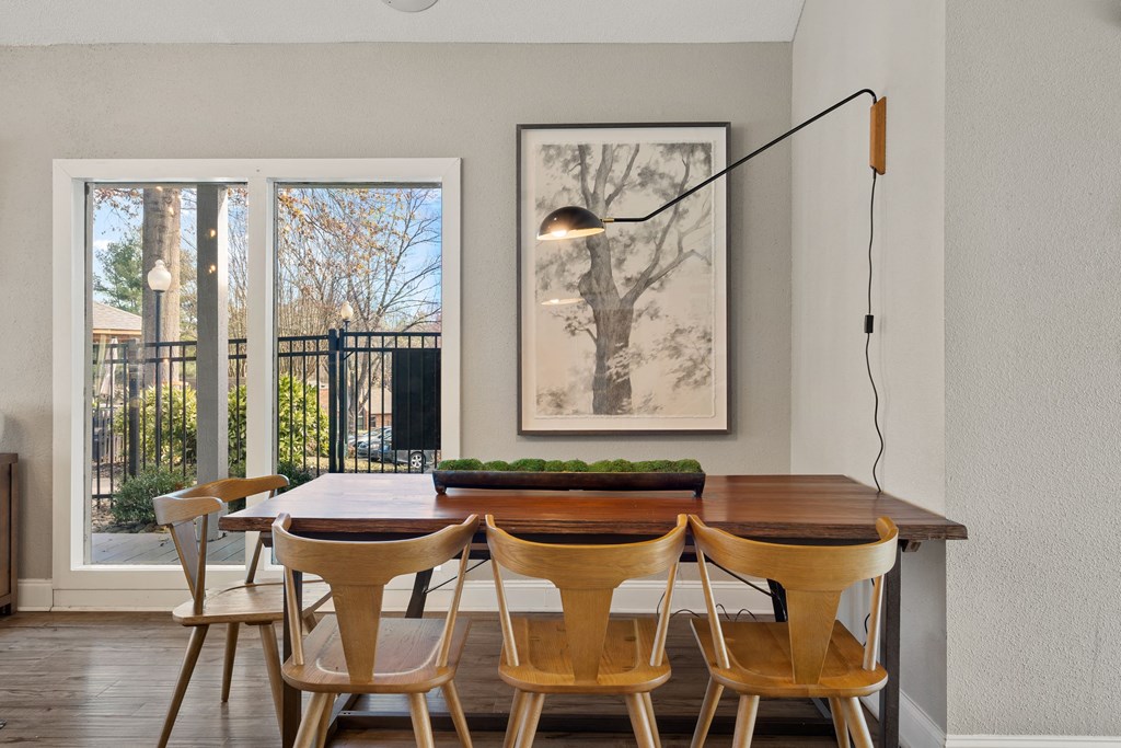 a dining room with a wooden table and chairs and a large window