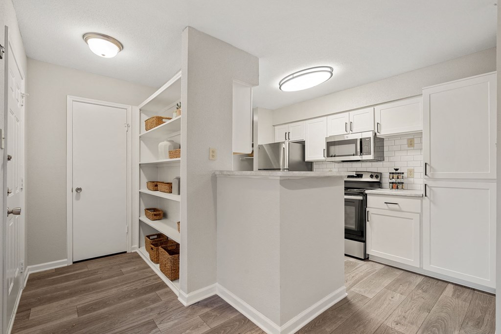 a renovated kitchen with white cabinets and white appliances and a white counter top