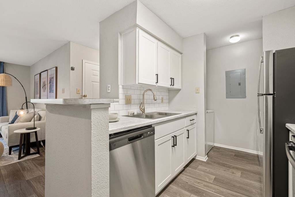 a renovated kitchen with white cabinets and a stainless steel dishwasher