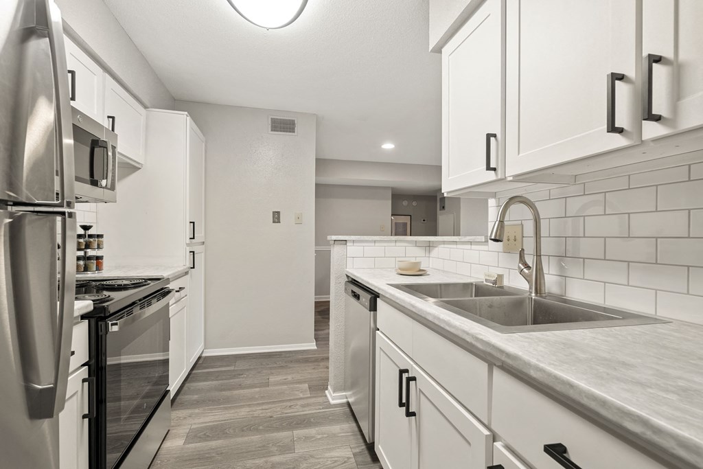 a renovated kitchen with white cabinets and stainless steel appliances
