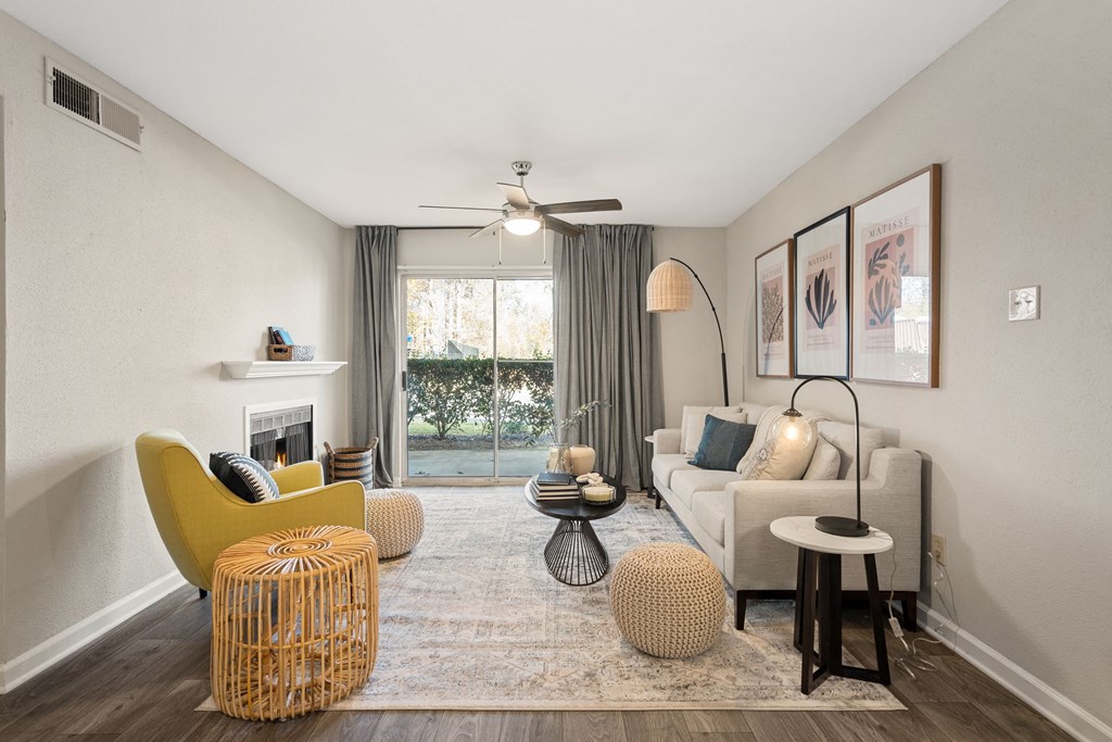 a living room with a couch and a chair and a ceiling fan