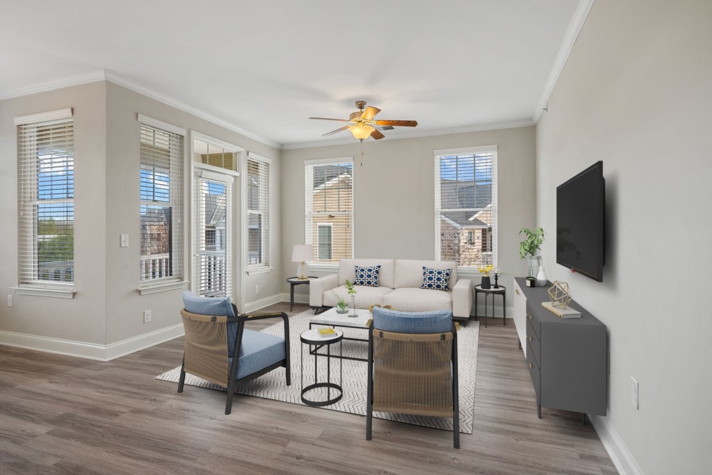 a living room with a couch and chairs and a tv