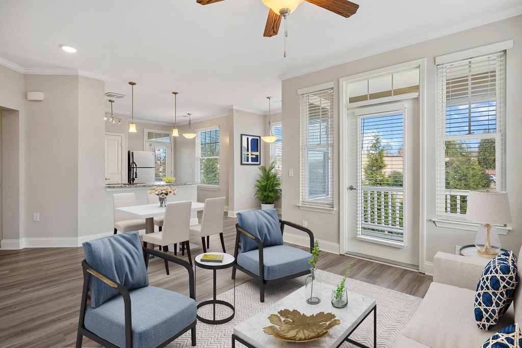 a living room with blue chairs and a dining room table