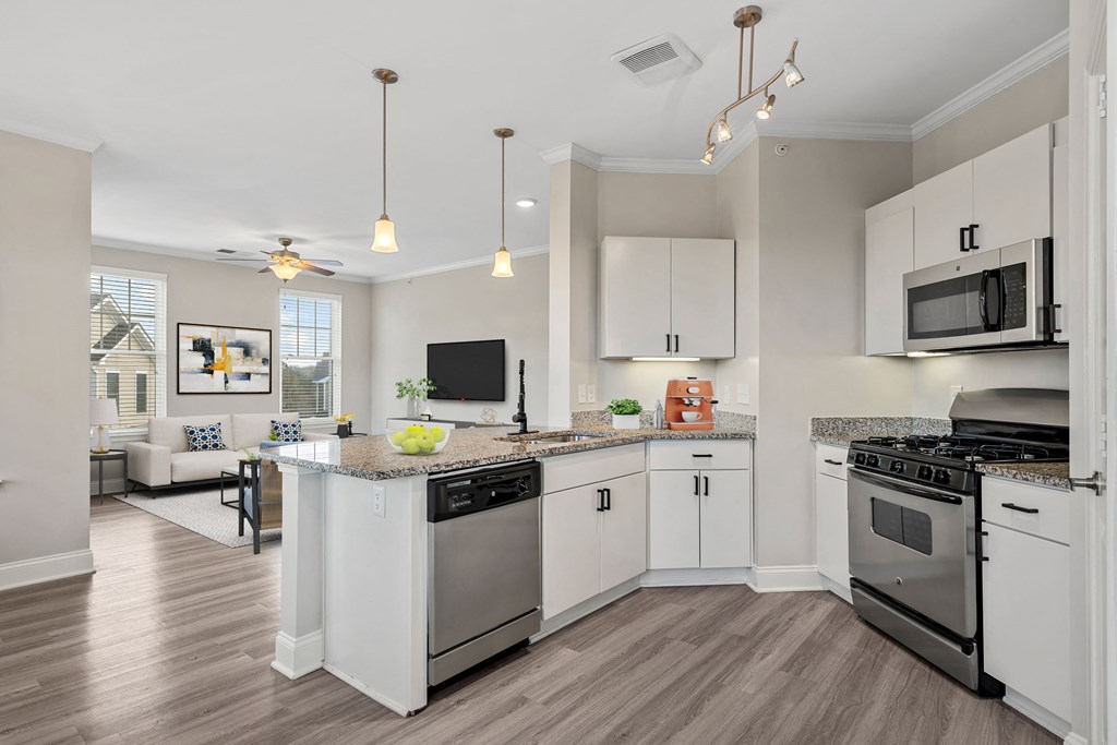 an open kitchen with stainless steel appliances and white cabinets