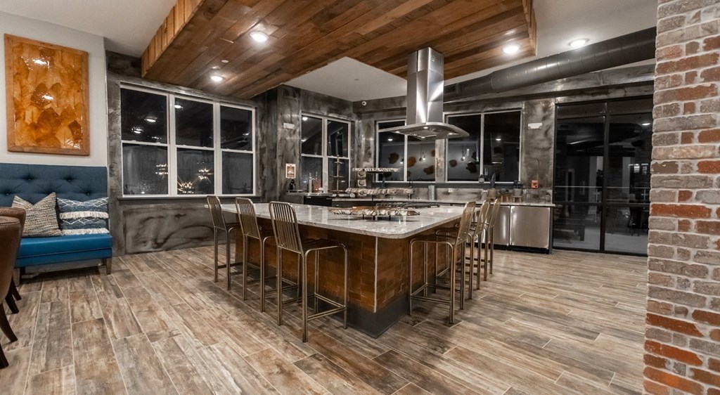 the kitchen has a large island with a marble counter top and stainless steel appliances